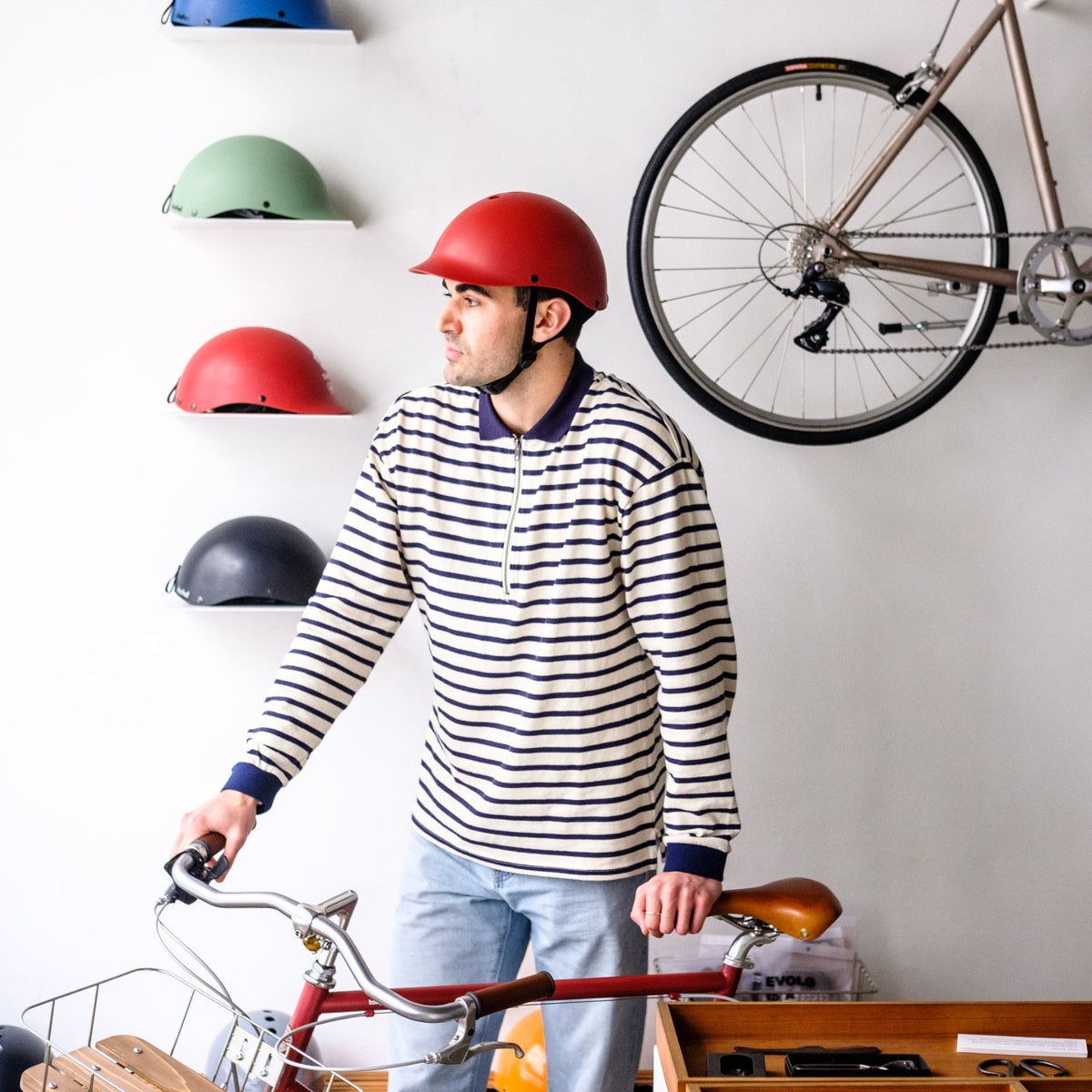 Man with his bike in a shop wearing a Dashel ReCycle Red bike helmet