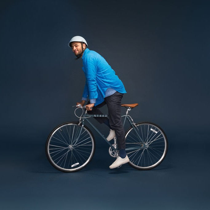 Man riding a bike wearing a Dashel ReCycle Sky Blue bike helmet