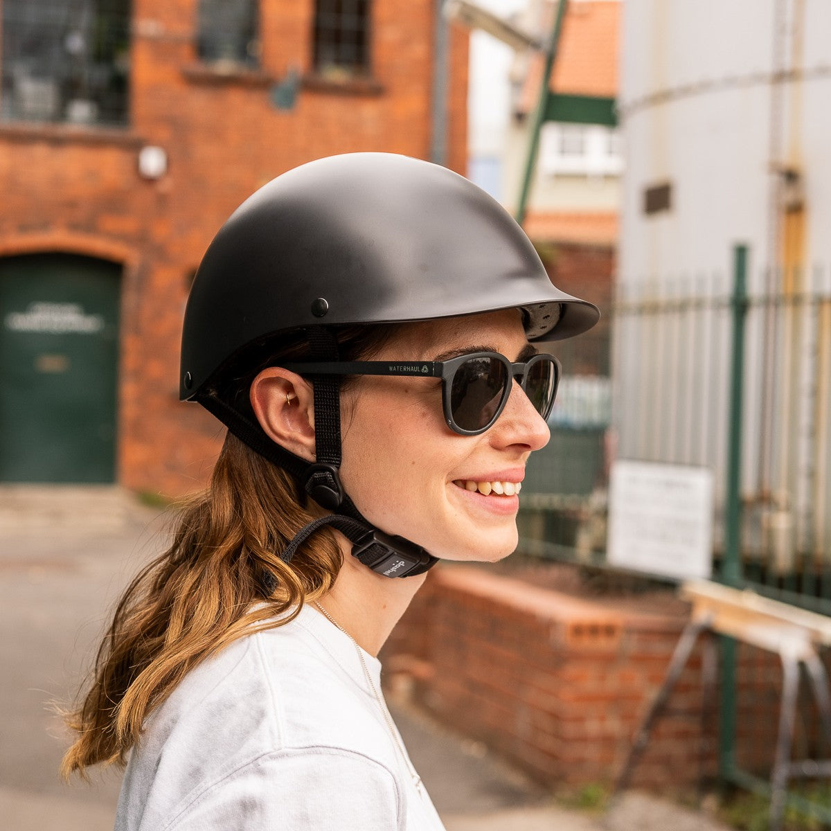 Woman in sunglasses wearing a Sea Shepherd x Dashel Ocean Edition Black bike helmet